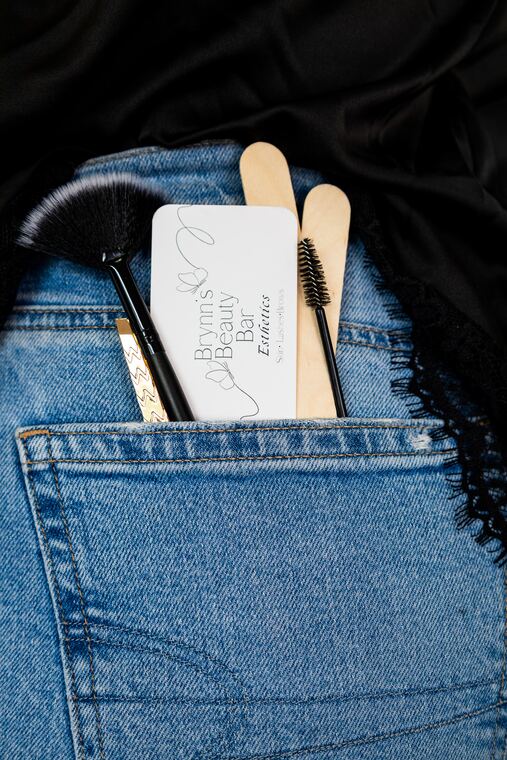 Brynn's Beauty Bar card, a brush and wax sticks in her back pocket