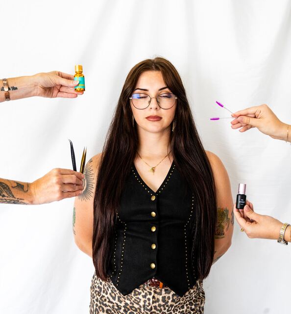 Alyssa surrounded by lash and brow tools held out by the other Plush artists
